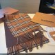 A warm and cozy scarf in soft cashmere. One side is adorned with a Burberry check pattern, while the other features a solid color design and the brand's logo. Produced in a 200-year-old specialist workshop in the Scottis