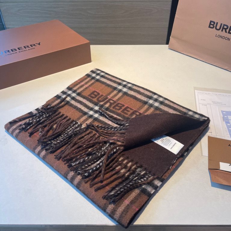 A warm and cozy scarf in soft cashmere. One side is adorned with a Burberry check pattern, while the other features a solid color design and the brand's logo. Produced in a 200-year-old specialist workshop in the Scottis