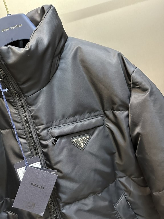 p675 PRADA Prada Reversible Down JacketPrada's iconic triangle logo is reinterpreted as a quilted pattern on this Re-Nylon stand-up jacket. The body has a modern, streetwear-inspired appeal, with an enameled metal triang