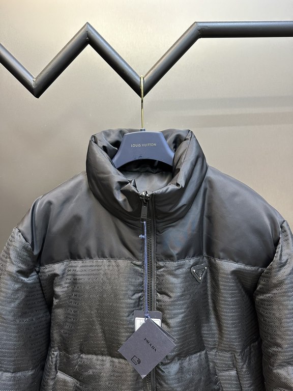 p675 PRADA Prada Reversible Down JacketPrada's iconic triangle logo is reinterpreted as a quilted pattern on this Re-Nylon stand-up jacket. The body has a modern, streetwear-inspired appeal, with an enameled metal triang