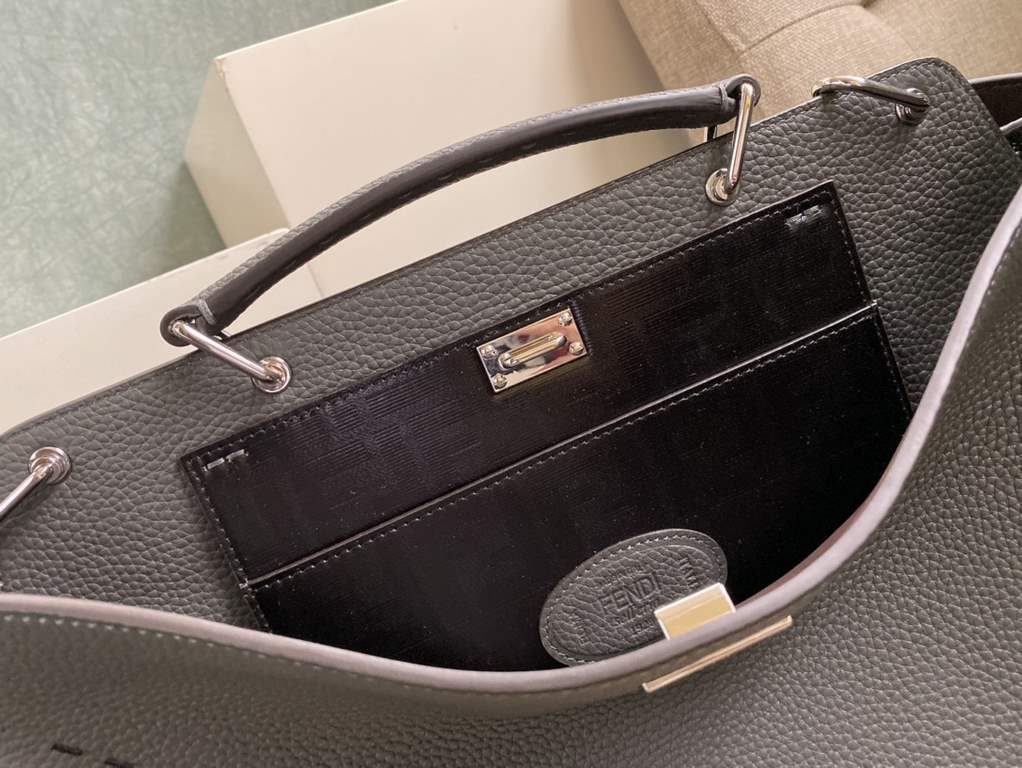 Minimalist design model lightweight handbag with two compartments separated by a rigid panel. Briefcase handles with adjustable, removable shoulder strap. Features interior patch pocket and signature twist lock. In gray 