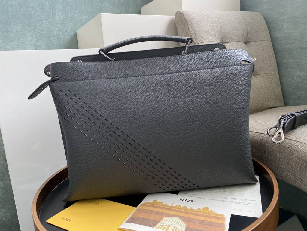 Minimalist design model lightweight handbag with two compartments separated by a rigid panel. Briefcase handles with adjustable, removable shoulder strap. Features interior patch pocket and signature twist lock. In gray 