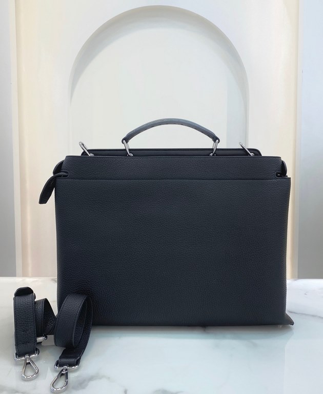 Minimalist design model lightweight handbag with two compartments separated by a rigid panel. Briefcase handles with adjustable, removable shoulder strap. Features interior patch pocket and signature twist lock. In black