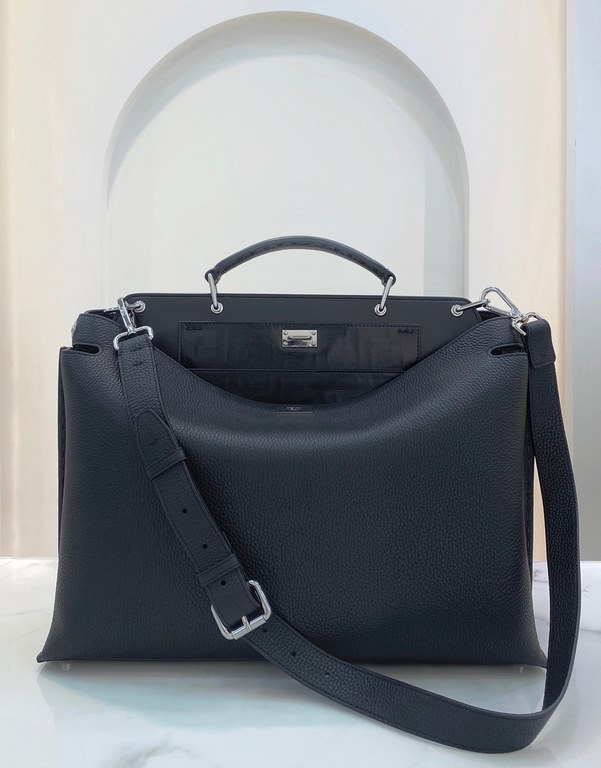 Minimalist design model lightweight handbag with two compartments separated by a rigid panel. Briefcase handles with adjustable, removable shoulder strap. Features interior patch pocket and signature twist lock. In black