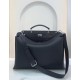 Minimalist design model lightweight handbag with two compartments separated by a rigid panel. Briefcase handles with adjustable, removable shoulder strap. Features interior patch pocket and signature twist lock. In black