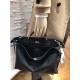 Minimalist design model lightweight handbag with two compartments separated by a rigid panel. Briefcase handles with adjustable, removable shoulder strap. Features interior patch pocket and signature twist lock. In black