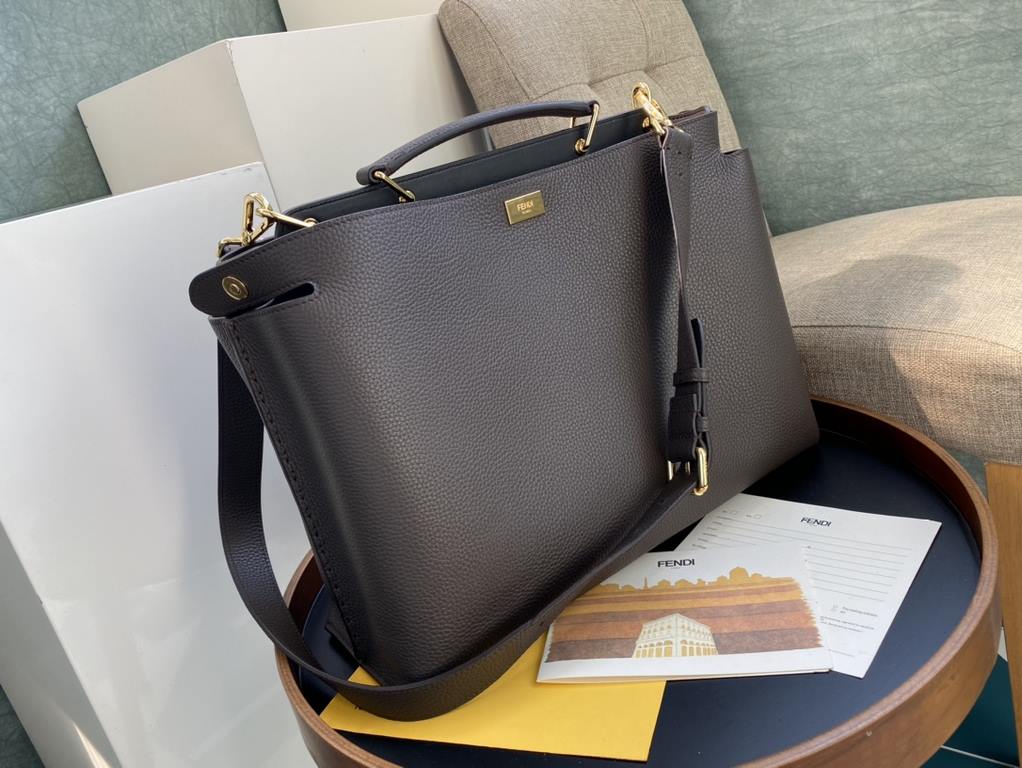 Minimalist design model lightweight handbag with two compartments separated by a rigid panel. Briefcase handles with adjustable, removable shoulder strap. Features interior patch pocket and signature twist lock. In dark 