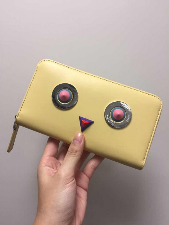 Family F Wheat yellow calf leather [rose][rose] zippered long wallet, [strong][strong] decorated with metal appliqués and multicolored plexiglass rivets forming a decorative pattern of rounded eyes, with a crotch catchin