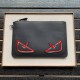 F Clutch bag in thin calf leather in black, embossed with a color-printed eye shape, zipper closure and engraved with the F logo on the back. 30.20cm-...