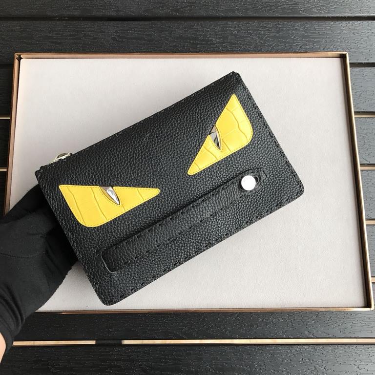 Black lychee leather clutch bag with white ribbed studs yellow crocodile BAG BUGS eye motif inlaid decoration, tote strap and zipper closure, three interior compartments with eight card slots.24cm