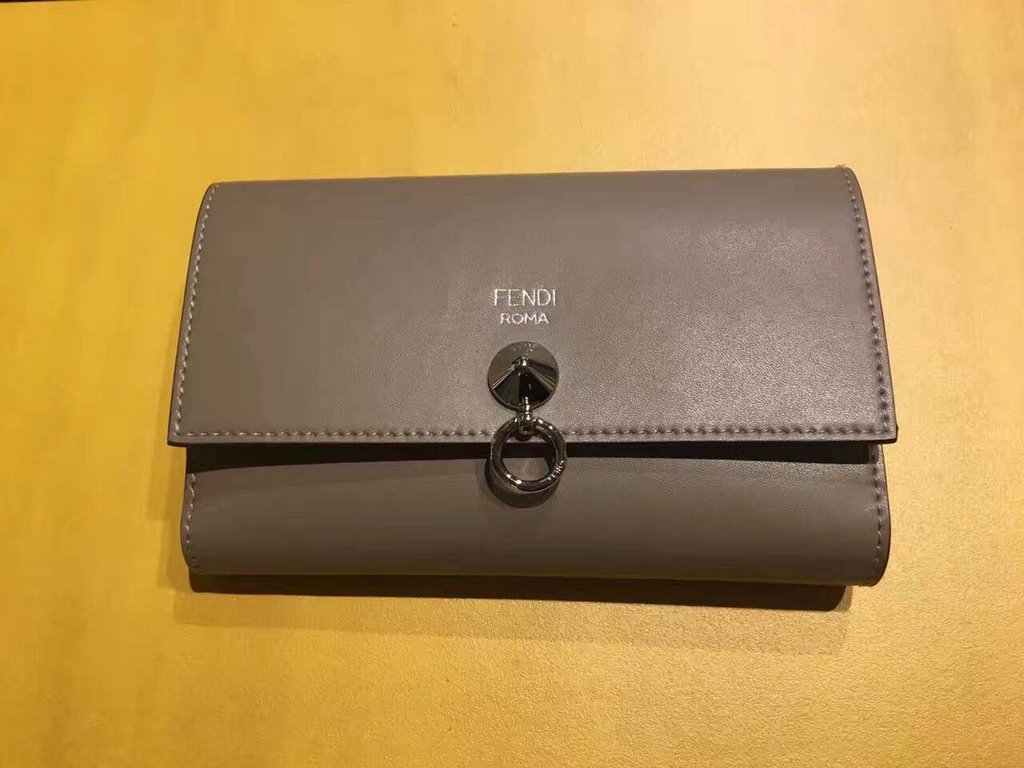 Newly designed soft small   cowhide leather centerfold, decorated with conical metal rivets, closed by a round loop, featuring a double crotch pocket, a back compartment, two patch pockets and 12 card slots    15cm (boxe