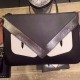 Slimline clutch bag in graphite black and gray calf leather, with stacked details and BAG BUGS eye appliques, zipper closure and logo on the back.30cm