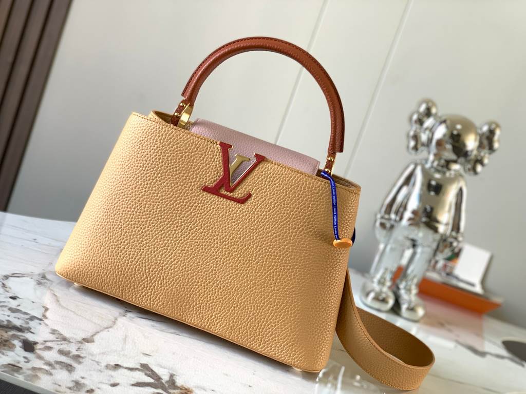 M59466 apricot yellow with light earthy gold clasp]A modern clash of shades in full-grain cowhide leather, this medium Capucines bag features the iconic LV alphabet and side loops, top handles and a detachable shoulder s