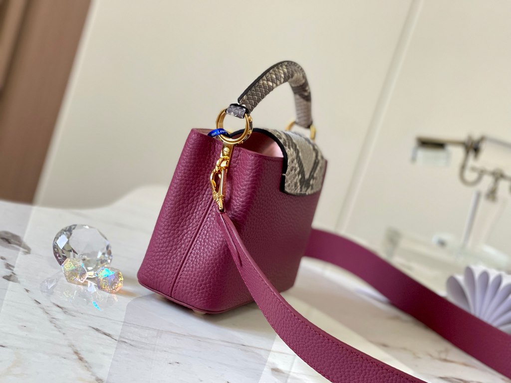 PremiumN82067 Grape Purple with Parisian Pink Python and Gold BucklesIn grained Taurillon leather with python flap, top handle and LV monogram, this Capucines mini bag has a luxurious feel. The contrasting light-colored 