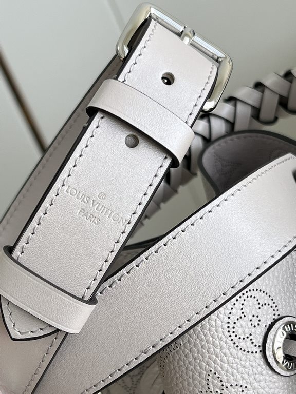 ExclusiveExclusive to M58788 in pearlized grey, this Muria bucket bag is crafted from cutout cowhide leather that lends a metallic sheen to the perforated Monogram pattern, and is finished with a leather name tag and key