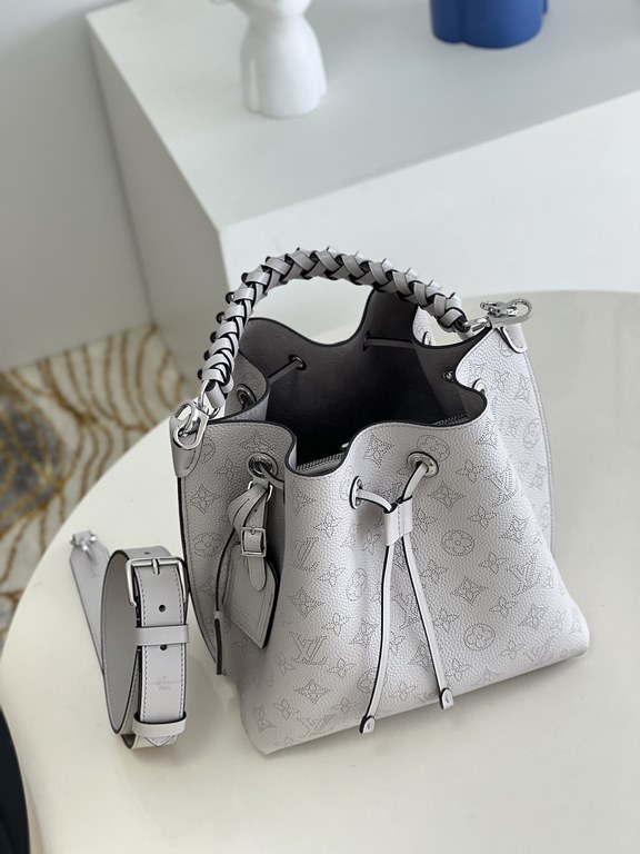 ExclusiveExclusive to M58788 in pearlized grey, this Muria bucket bag is crafted from cutout cowhide leather that lends a metallic sheen to the perforated Monogram pattern, and is finished with a leather name tag and key