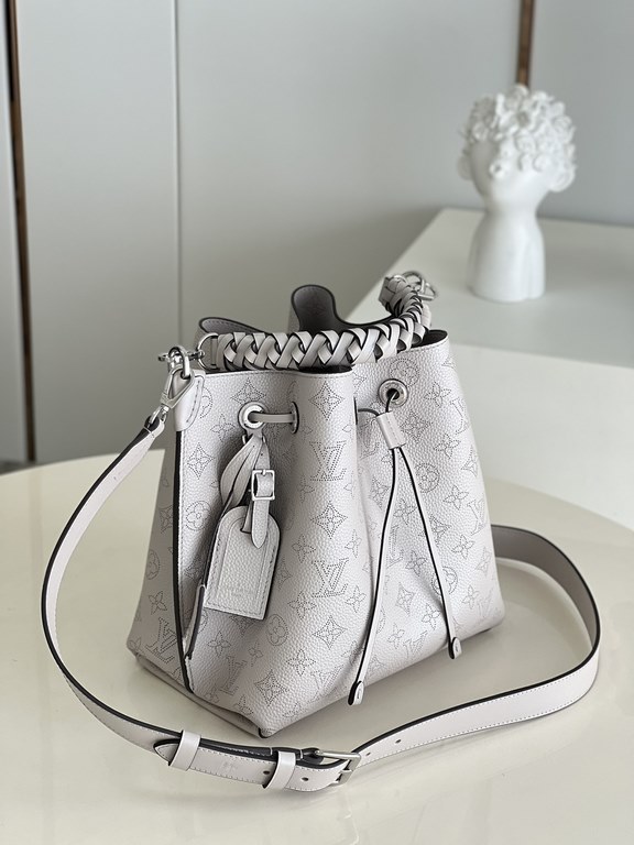 ExclusiveExclusive to M58788 in pearlized grey, this Muria bucket bag is crafted from cutout cowhide leather that lends a metallic sheen to the perforated Monogram pattern, and is finished with a leather name tag and key