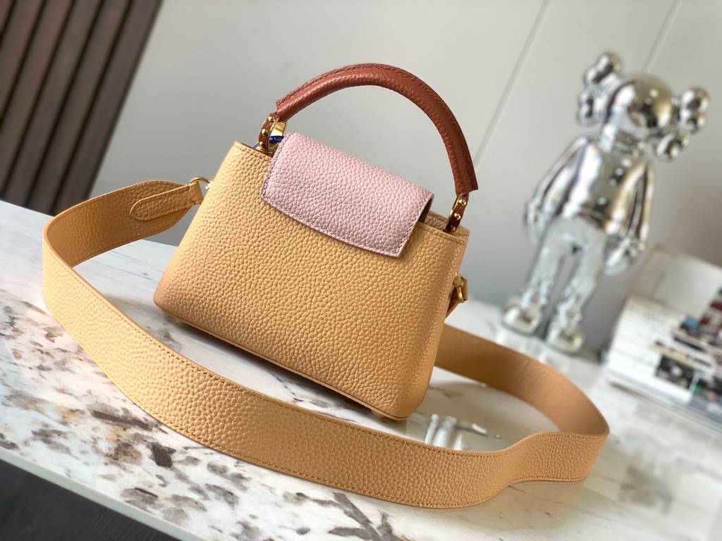 M59440 Apricot with Light Earth Gold Buckle]This Capucines mini bag is crafted from grained cowhide leather and features a color-blocked body and top handle and flap, LV lettering for visual interest, and a wide, removab