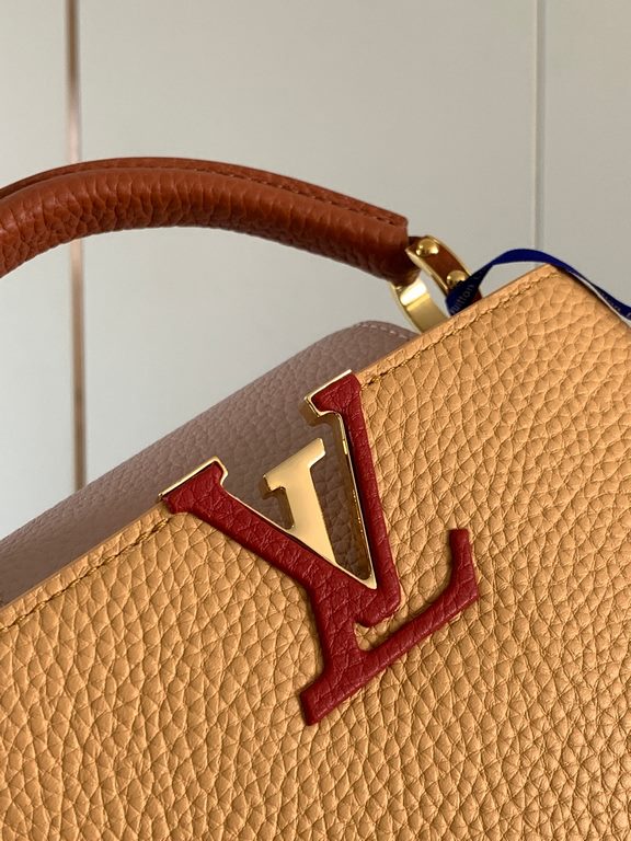 M59440 Apricot with Light Earth Gold Buckle]This Capucines mini bag is crafted from grained cowhide leather and features a color-blocked body and top handle and flap, LV lettering for visual interest, and a wide, removab