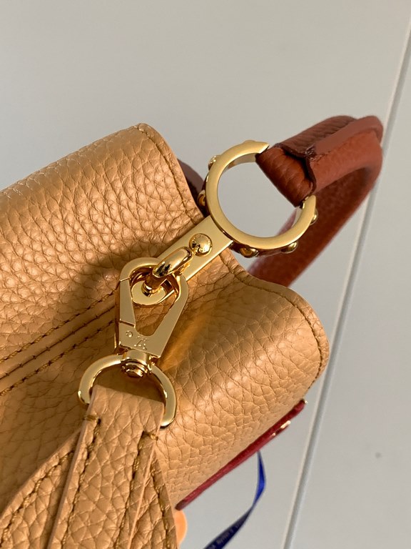 M59440 Apricot with Light Earth Gold Buckle]This Capucines mini bag is crafted from grained cowhide leather and features a color-blocked body and top handle and flap, LV lettering for visual interest, and a wide, removab