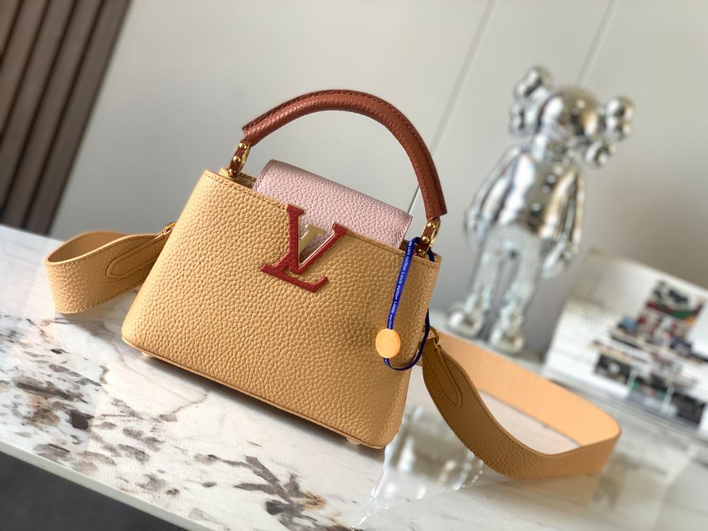 M59440 Apricot with Light Earth Gold Buckle]This Capucines mini bag is crafted from grained cowhide leather and features a color-blocked body and top handle and flap, LV lettering for visual interest, and a wide, removab