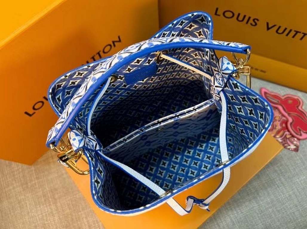 The new M22986 NeoNoé Bucket Bag in blue is made of muted canvas with a Giant Monogram print, giving the LV and Monogram florals a watercolor effect in varying shades, and features a drawstring and central snap closure i