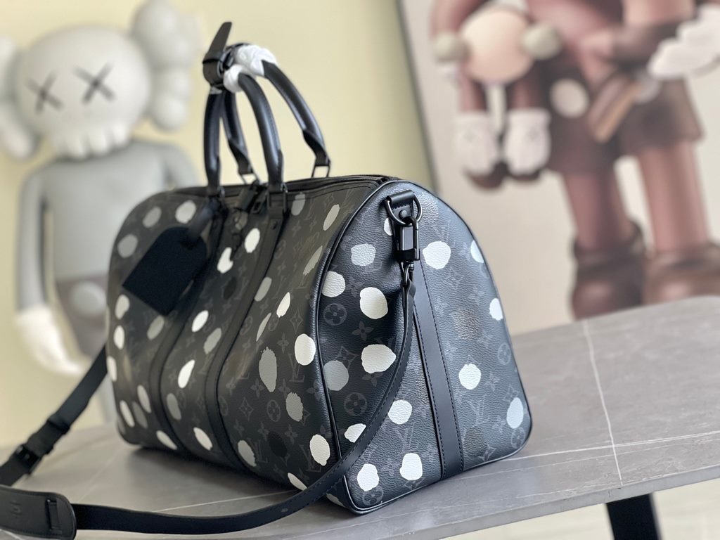 The M46400 LV x YK Keepall 45 travel bag from the Louis Vuitton x Yayoi Kusama collaboration celebrates the fusion of artistic creativity and craftsmanship with polka dots on Monogram Eclipse canvas, once again making it