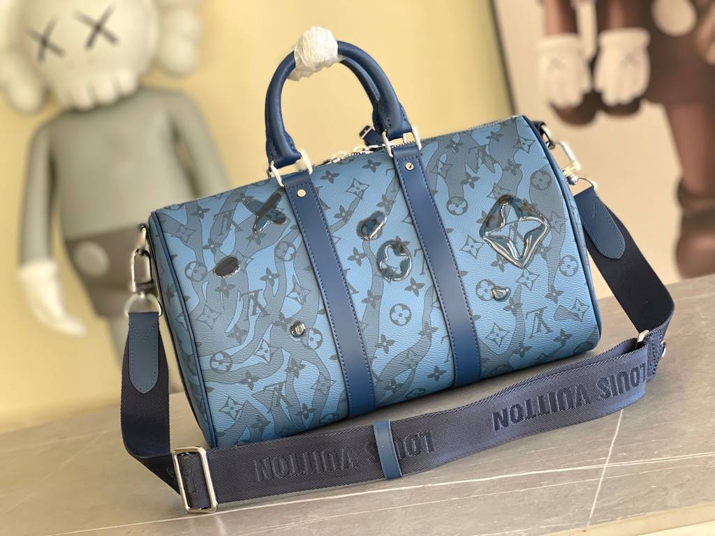 The M22573 Keepall Bandoulière 35 is crafted from Monogram Aquagarden canvas, making the Monogram floral and LV letters resemble gently cascading drops of water. The side straps and top rolled leather handles are in keep