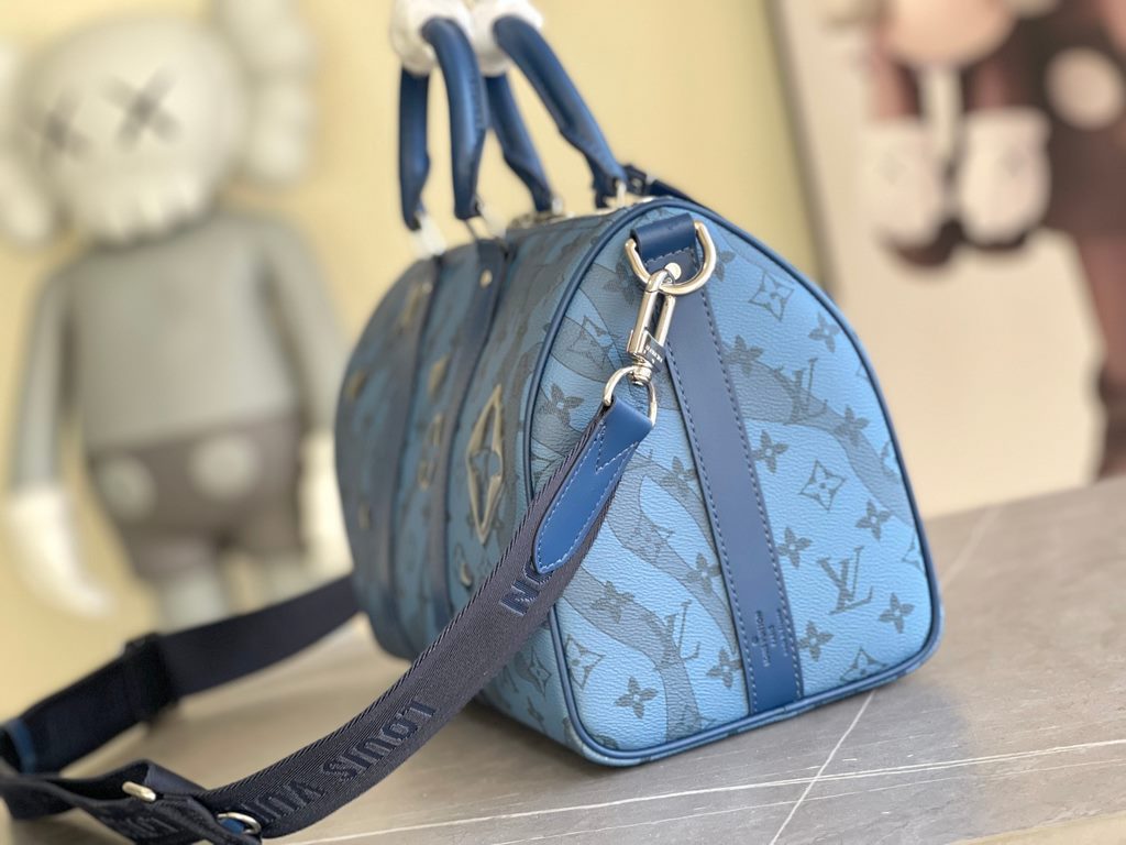 The M22573 Keepall Bandoulière 35 is crafted from Monogram Aquagarden canvas, making the Monogram floral and LV letters resemble gently cascading drops of water. The side straps and top rolled leather handles are in keep