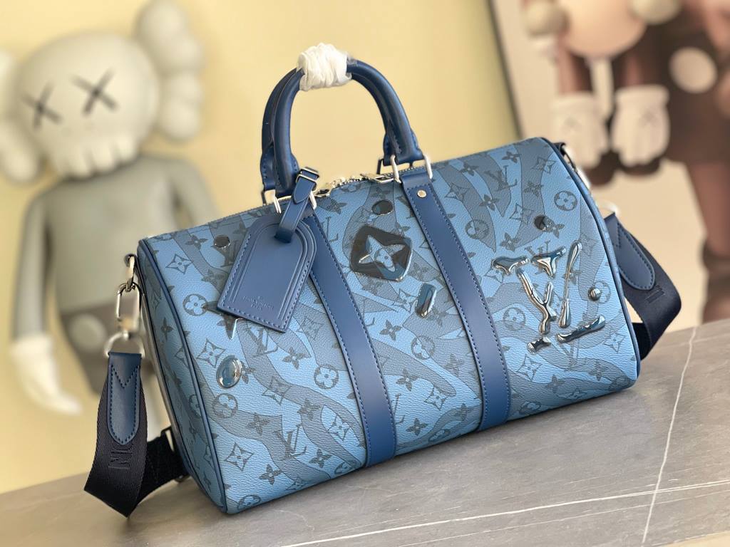 The M22573 Keepall Bandoulière 35 is crafted from Monogram Aquagarden canvas, making the Monogram floral and LV letters resemble gently cascading drops of water. The side straps and top rolled leather handles are in keep