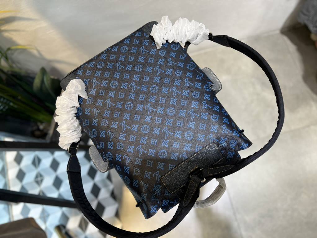 M46338 This Christopher MM backpack is made of coated canvas with a blue LV and Monogram floral pattern on a dark background. Finished with black leather trims and contrasting stitching, the bag is complemented by the LV