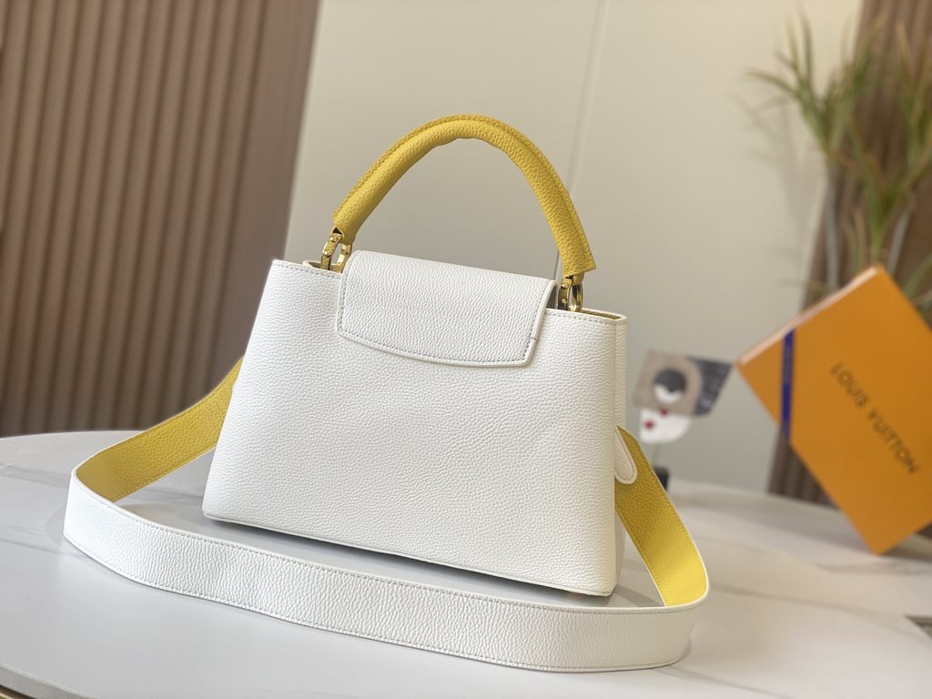 EXCLUSIVE PHOTO - M59434This medium Capucines BB handbag is shaped in full-grain cowhide leather in the compact size of the Capucines collection, with LV's letters, signature side loops, and a floral Monogram flap.Detail