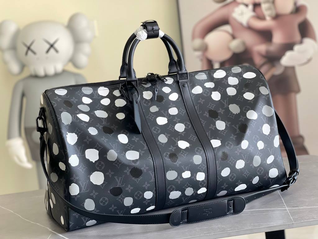 The M46401LV x YK Keepall 55 travel bag from the Louis Vuitton x Yayoi Kusama collaboration celebrates the fusion of artistic creativity and craftsmanship with polka dots on Monogram Eclipse canvas, once again making it 