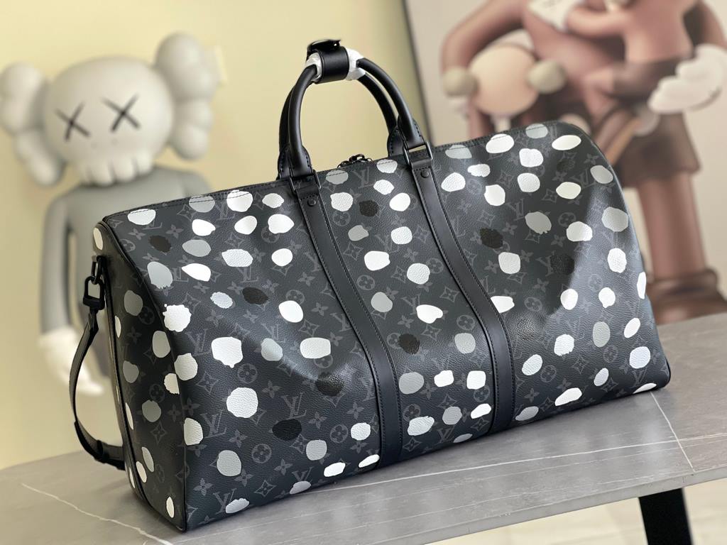 The M46401LV x YK Keepall 55 travel bag from the Louis Vuitton x Yayoi Kusama collaboration celebrates the fusion of artistic creativity and craftsmanship with polka dots on Monogram Eclipse canvas, once again making it 