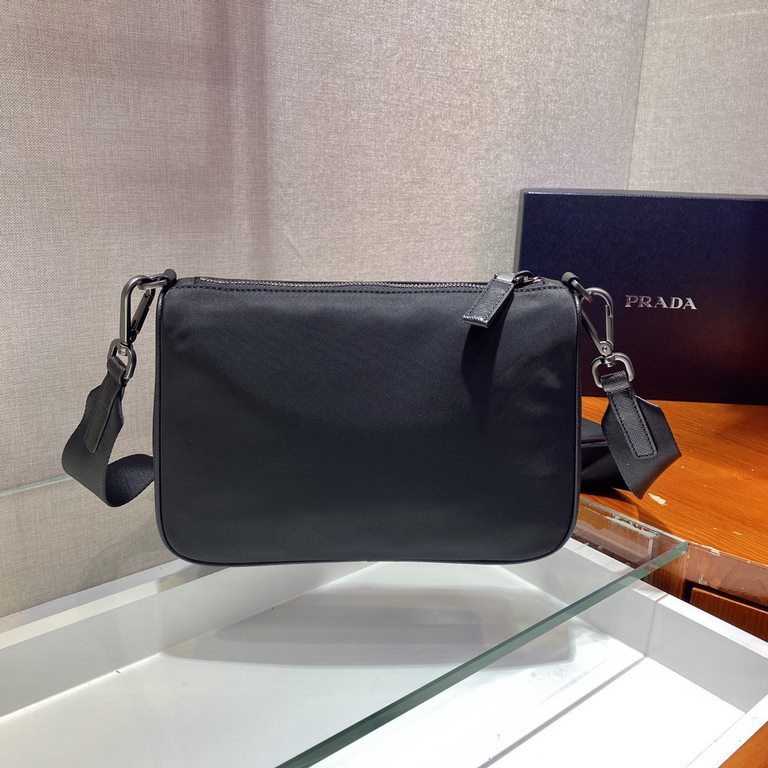 Fine Saffiano leather inserts and a chic woven nylon and leather shoulder strap with removable pouch create a distinctive style. The enameled triangular metal logo and recycled nylon logo on the front are a signature of 