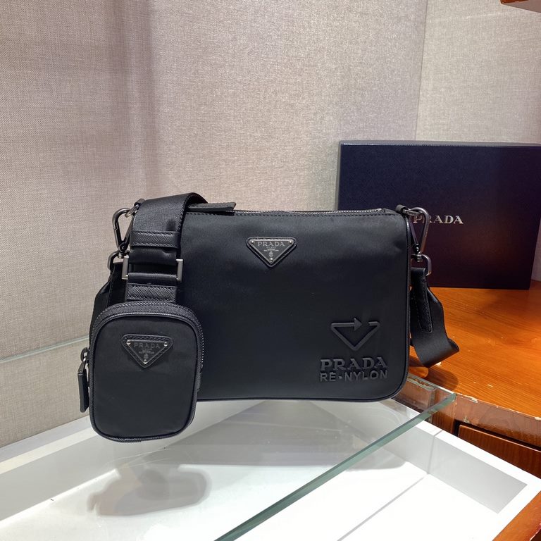 Fine Saffiano leather inserts and a chic woven nylon and leather shoulder strap with removable pouch create a distinctive style. The enameled triangular metal logo and recycled nylon logo on the front are a signature of 