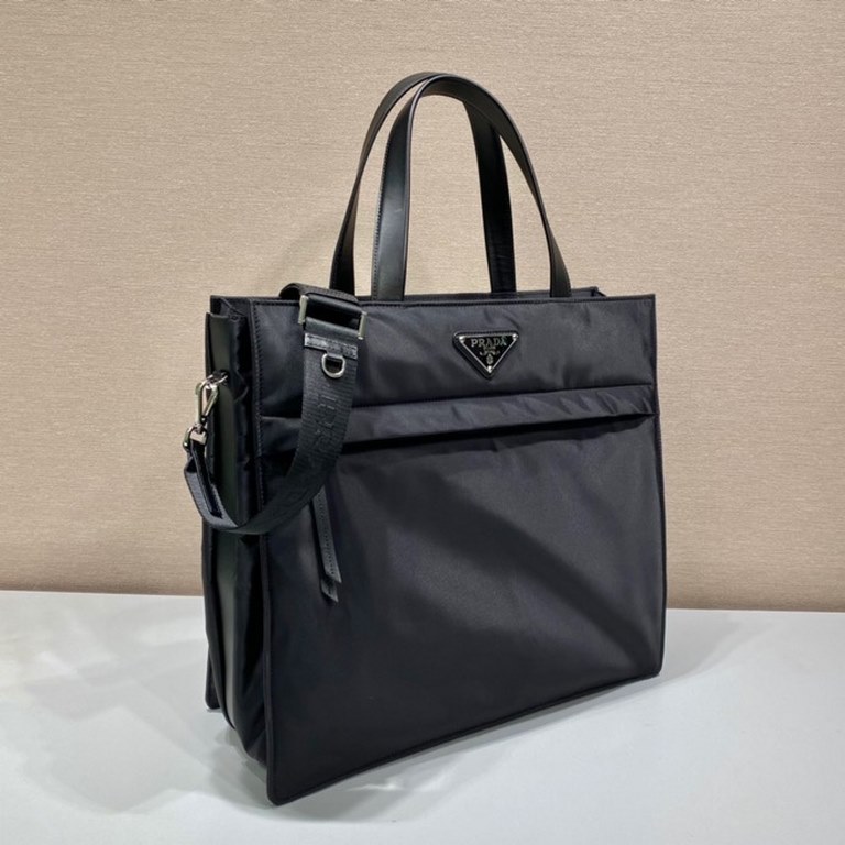 Upgraded Tote Bag 2VG076This tote bag presents a compact square design adorned with leather details. The iconic enameled triangle logo on the front emphasizes the brand's style. Fitted with a long detachable shoulder str