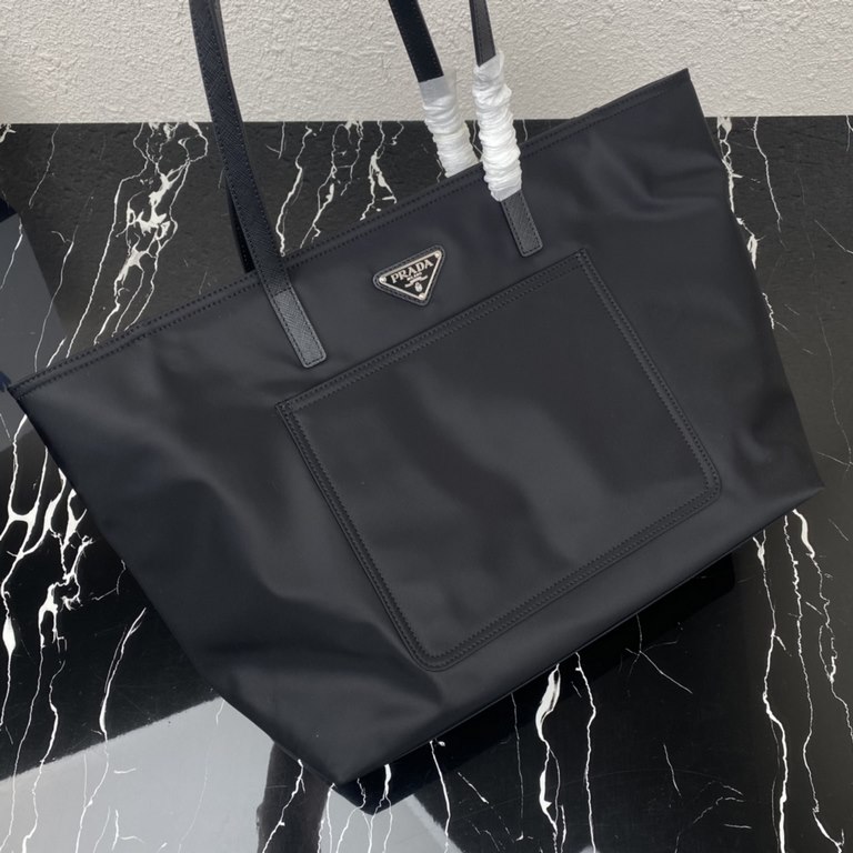 [Top Original]  New Tote Bag 1BG052  This traditional tote bag comes with a spacious front pocket and Saffiano leather carry handle. The distinctive triangular logo embellishment is a signature of the brand. Nylon was in