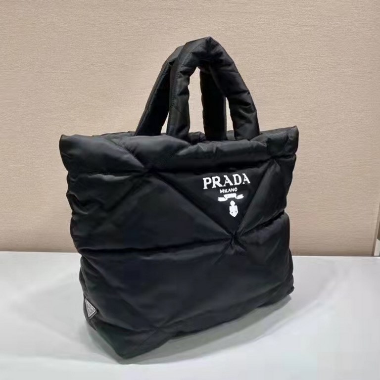 Prada's newest nylon tote bag, the 2VG082, features a lined and stitched triangle, a printed logo on the front, an enameled metal triangle logo on the side, and a cabinet with zippered and patch pockets. The iconic Prada