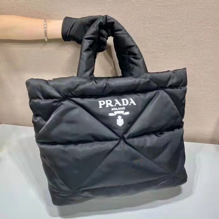 Prada's newest nylon tote bag, the 2VG082, features a lined and stitched triangle, a printed logo on the front, an enameled metal triangle logo on the side, and a cabinet with zippered and patch pockets. The iconic Prada