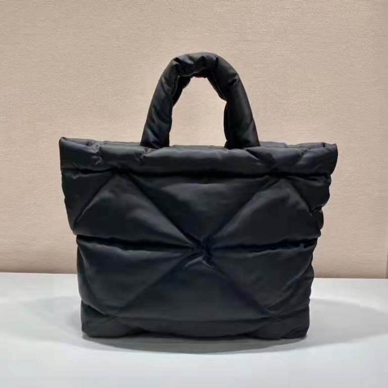 Prada's newest nylon tote bag, the 2VG082, features a lined and stitched triangle, a printed logo on the front, an enameled metal triangle logo on the side, and a cabinet with zippered and patch pockets. The iconic Prada