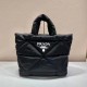 Prada's newest nylon tote bag, the 2VG082, features a lined and stitched triangle, a printed logo on the front, an enameled metal triangle logo on the side, and a cabinet with zippered and patch pockets. The iconic Prada