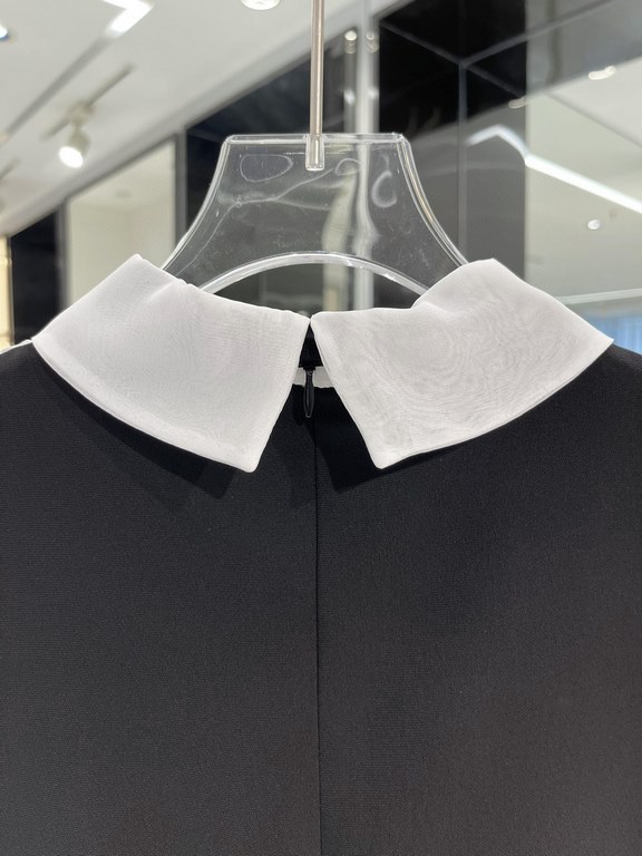 A-line version of the black skirt body, not too close to the curve, slimming and thin. Spliced with white crepe organza, elegant small pointed collar decorated with black straps, gentle ageing. Chest decorated with verti