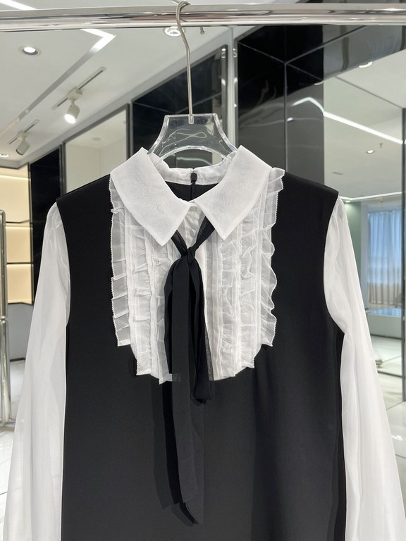 A-line version of the black skirt body, not too close to the curve, slimming and thin. Spliced with white crepe organza, elegant small pointed collar decorated with black straps, gentle ageing. Chest decorated with verti