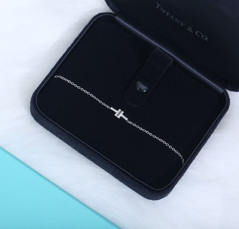 A delicate double chain with a fashion-forward T-pattern and dazzling diamonds for a touch of elegance. The classic and glamorous design of the T Collection features delicate facets that reflect love. Pair with other T C